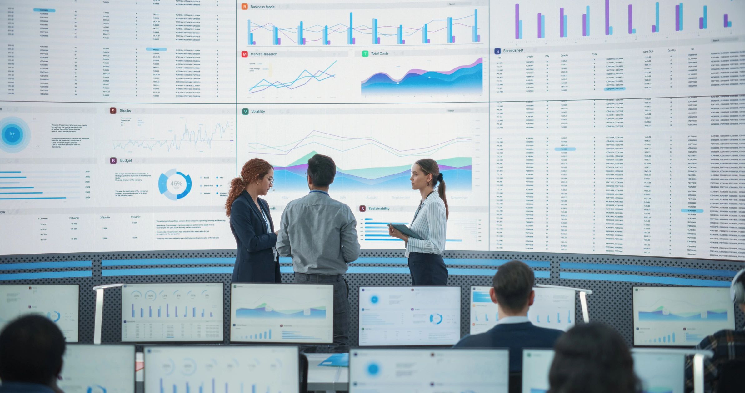 Data team reviewing reports on a large digital screen